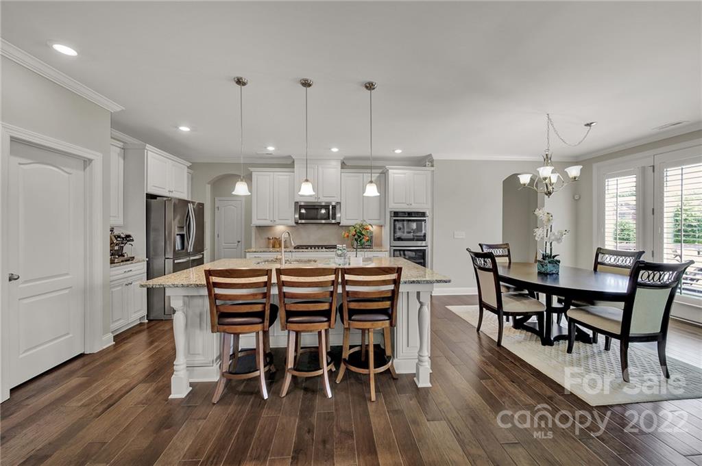 207 Kingsdown Avenue Charlotte, NC 28270 - Photo 14 of 48 a dining area with furniture a kitchen and chandelier