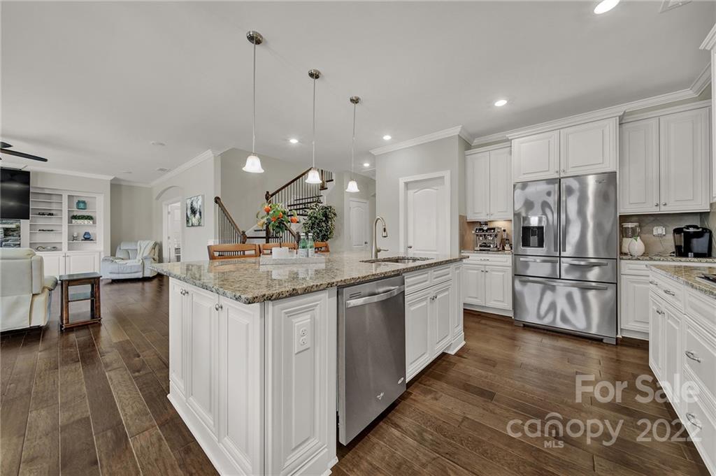 207 Kingsdown Avenue Charlotte, NC 28270 - Photo 15 of 48 a kitchen with stainless steel appliances kitchen island granite countertop a stove a sink a refrigerator and white cabinets with wooden floor