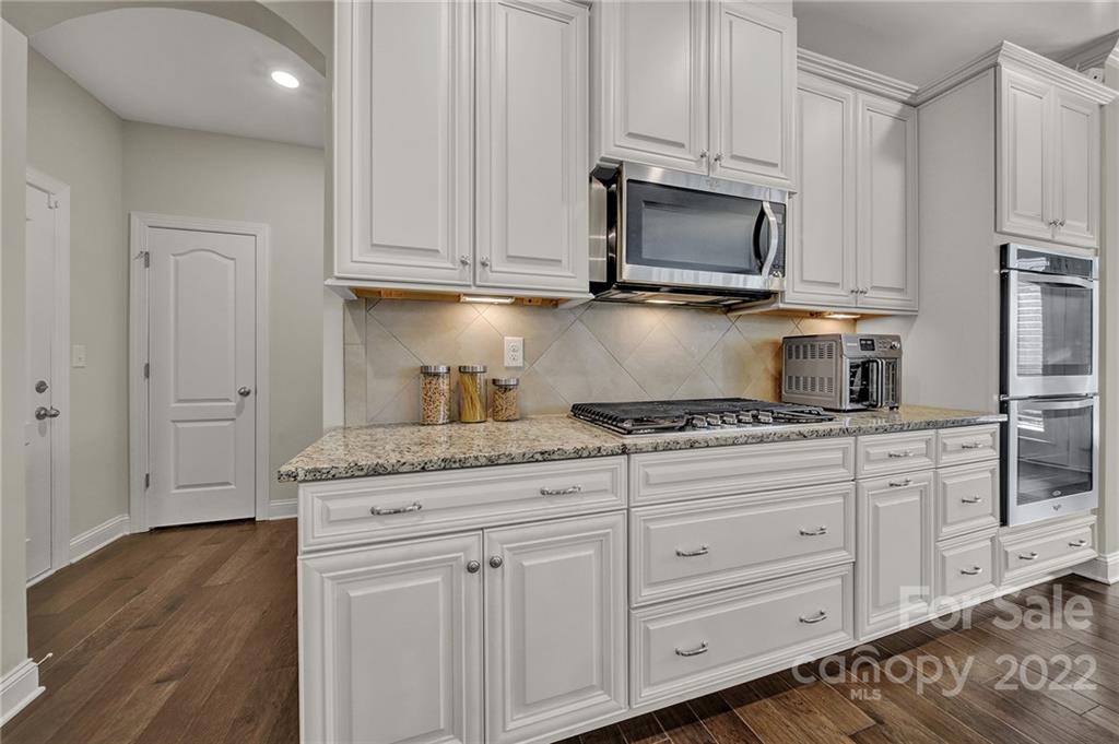 207 Kingsdown Avenue Charlotte, NC 28270 - Photo 17 of 48 a kitchen with granite countertop white cabinets and stainless steel appliances