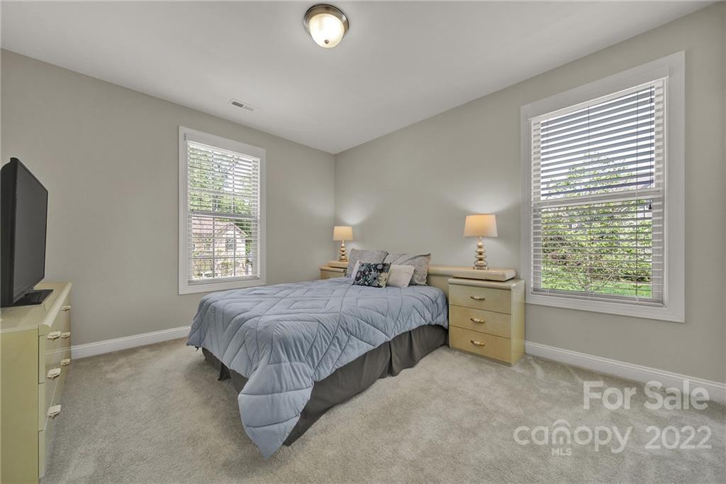 207 Kingsdown Avenue Charlotte, NC 28270 - Photo 25 of 48 a spacious bedroom with a bed and a flat tv screen on the dresser