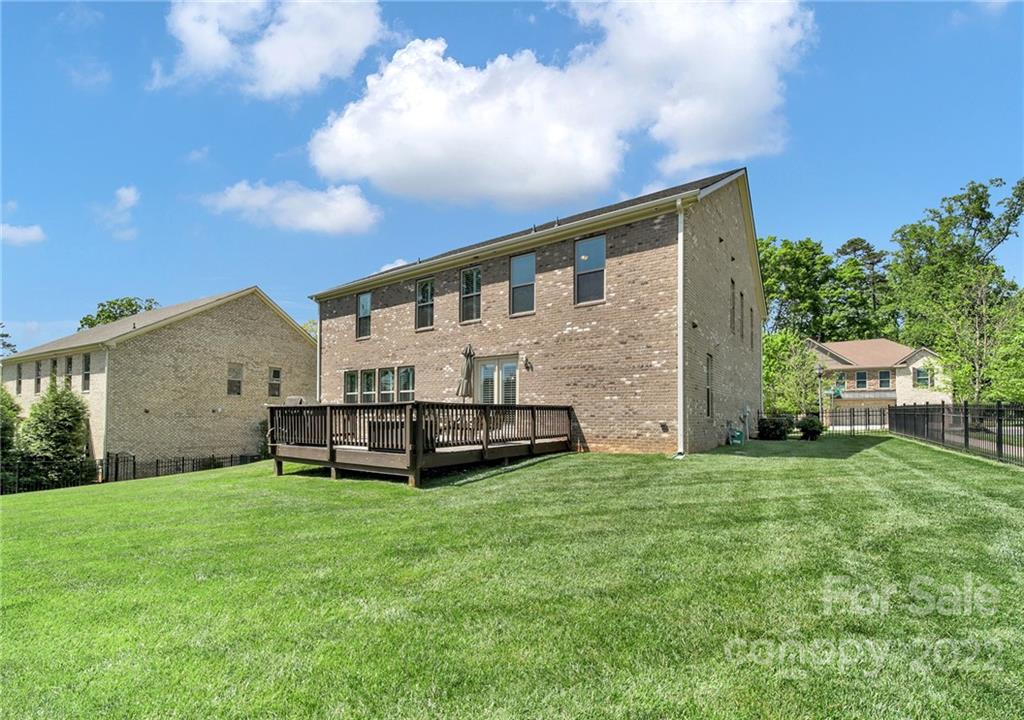 207 Kingsdown Avenue Charlotte, NC 28270 - Photo 44 of 48 a backyard of a house with table and chairs and wooden fence