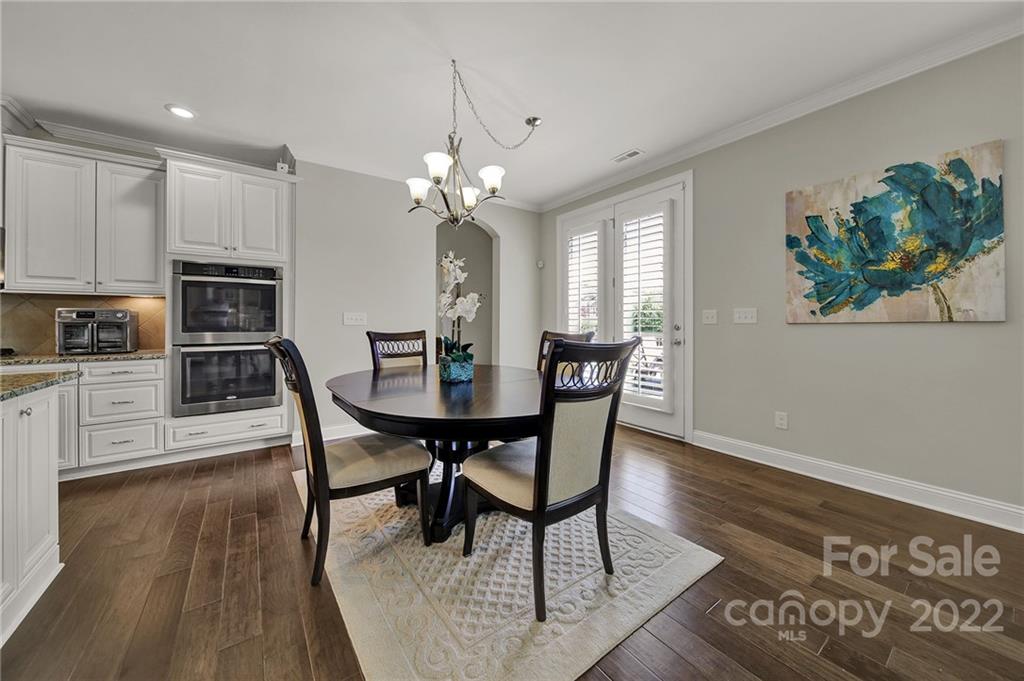 207 Kingsdown Avenue Charlotte, NC 28270 - Photo 10 of 48 a view of a dining room with furniture a chandelier and wooden floor