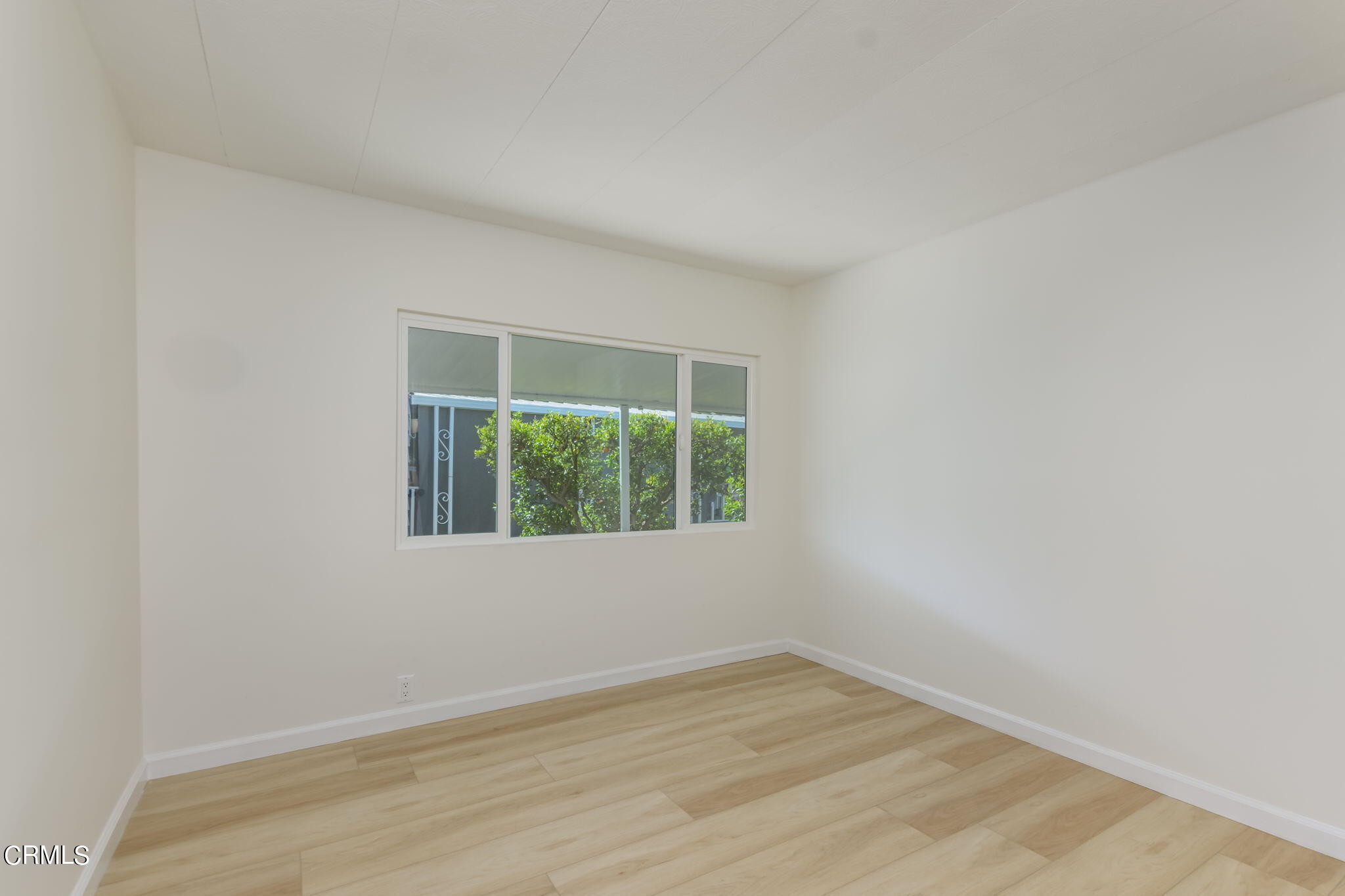 132 Rainbow Drive, Unit 158 Oxnard, CA 93033 - Photo 11 of 21 an empty room with wooden floor and windows