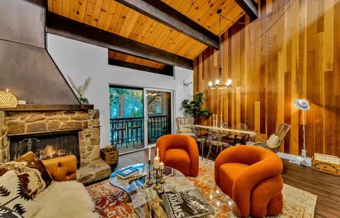 a living room with furniture a fireplace and large window