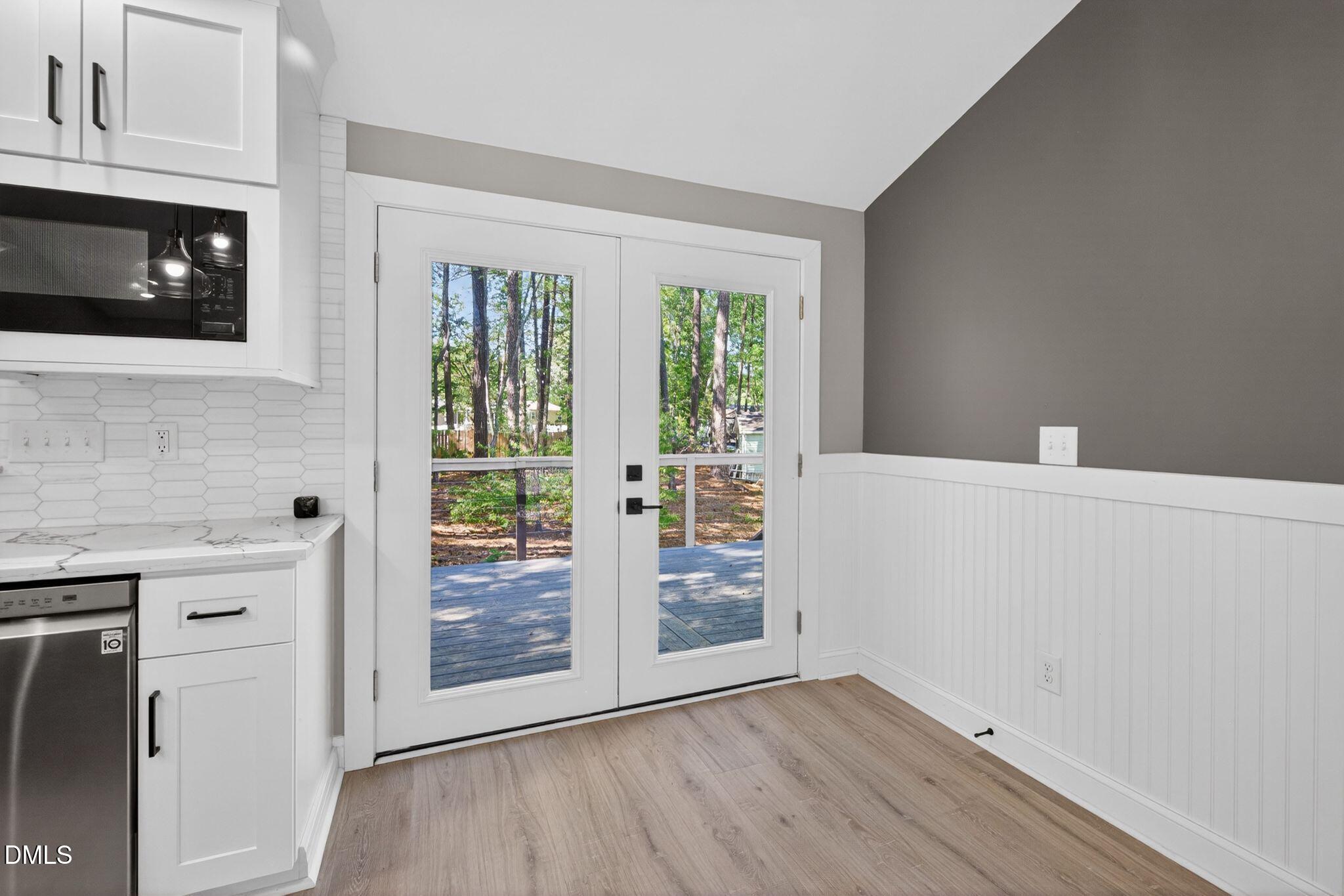 313 Crown Oaks Drive Raleigh, NC 27615 - Photo 14 of 60 a view of an empty room with wooden floor and a window