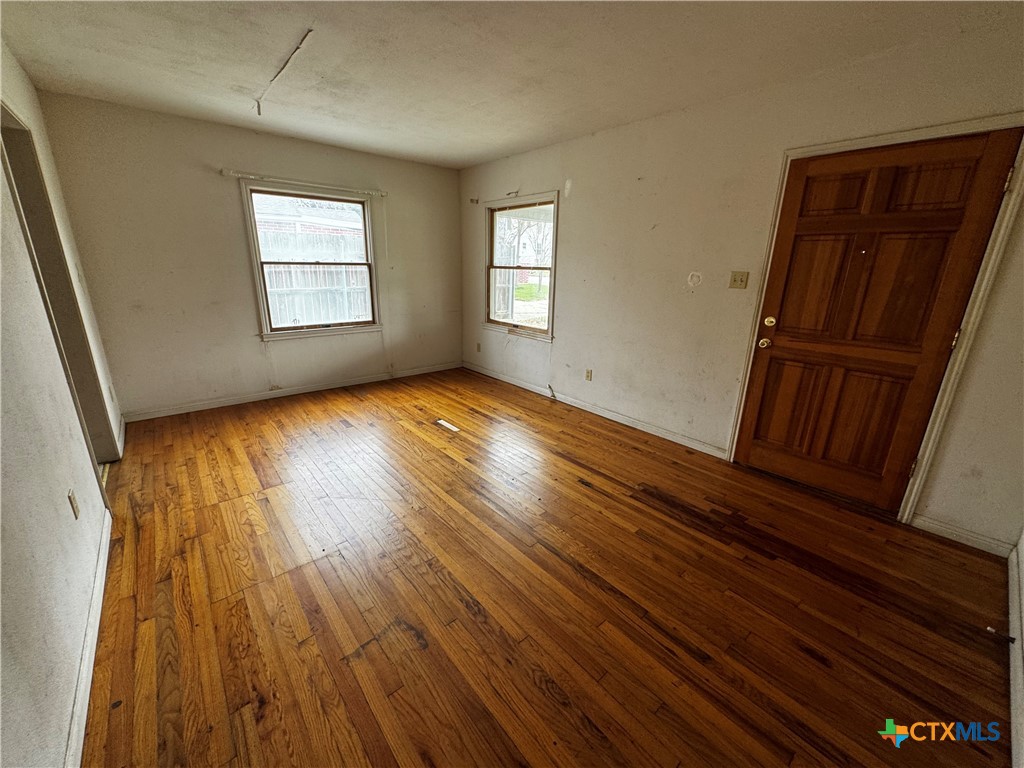 1010 South 17th Street Temple, TX 76504 - Photo 5 of 30 a view of an empty room with wooden floor and a window
