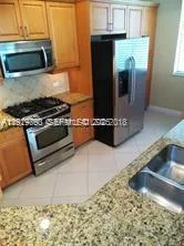 a kitchen with granite countertop a stove and a microwave