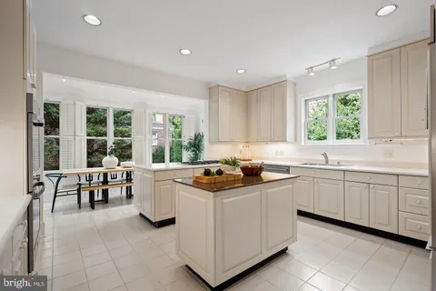 a kitchen with granite countertop cabinets a stove a sink and a dining table