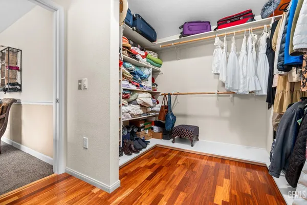 a view of walk in closet with clothes and shoes