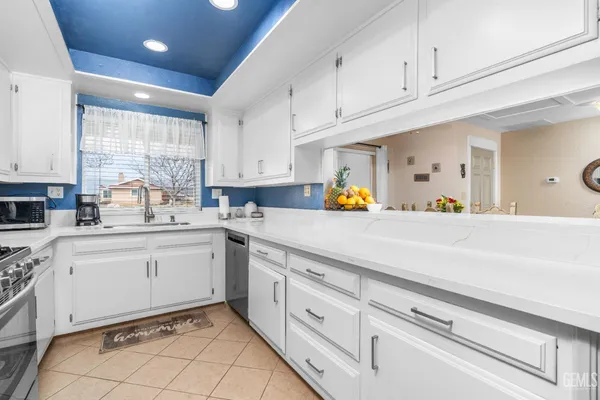 a kitchen with white cabinets and appliances