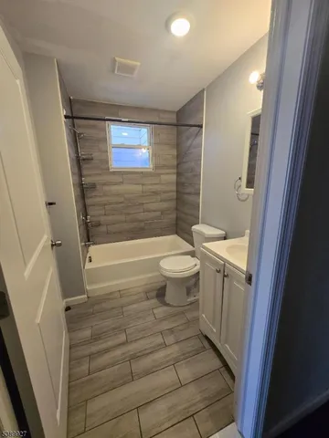 a bathroom with a sink a toilet a mirror and shower