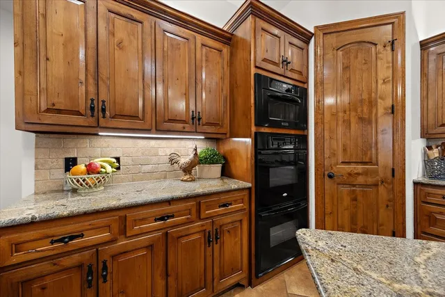 a kitchen with stainless steel appliances granite countertop a sink and a refrigerator