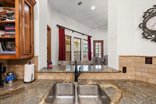 a kitchen with stainless steel appliances granite countertop a refrigerator a stove and a sink with wooden floor