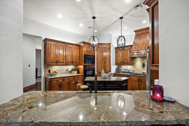 a kitchen with stainless steel appliances granite countertop a refrigerator and cabinets