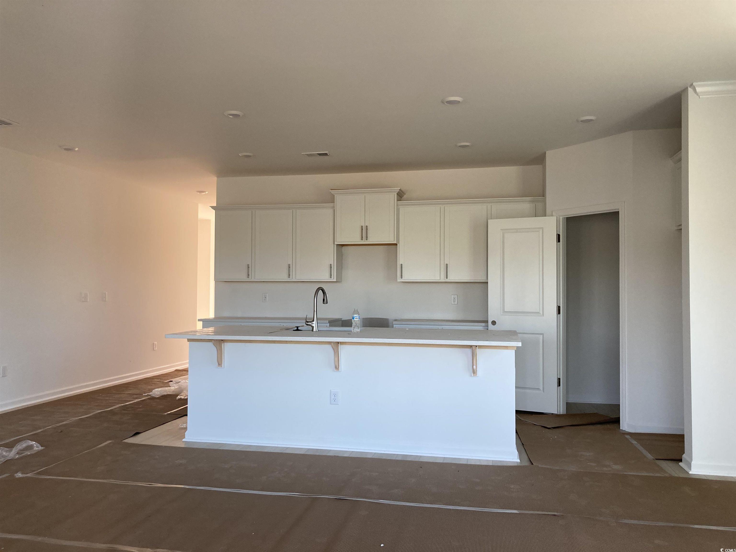 146 River Birch Drive Loris, SC 29569 - Photo 3 of 21 Kitchen with a breakfast bar, an island with sink, and white cabinets