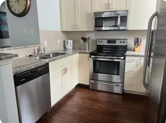 a kitchen with stainless steel appliances granite countertop a stove a microwave and a refrigerator