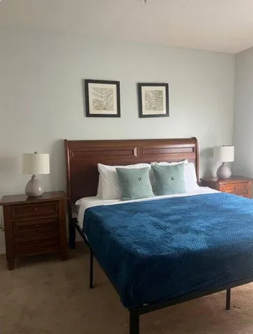 a bed sitting in a bedroom next to a lamp