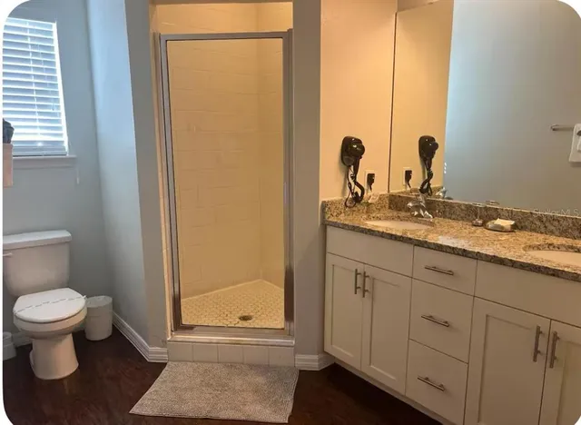 a bathroom with a granite countertop sink and a toilet