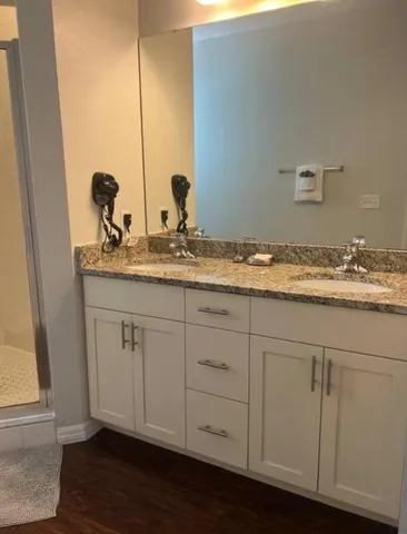 a bathroom with a granite countertop sink and a mirror