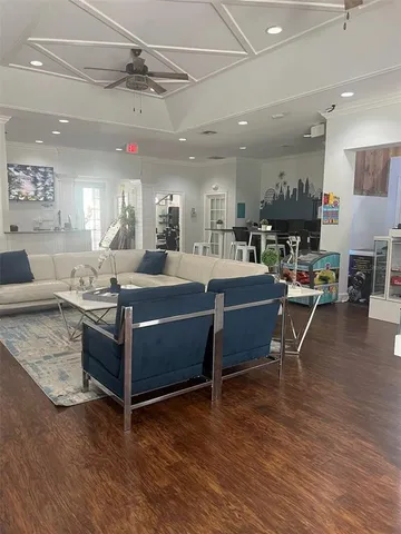 a living room with furniture a flat screen tv and kitchen view