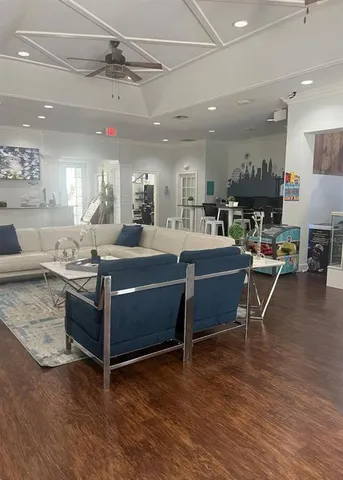 a living room with kitchen furniture and a wooden floor