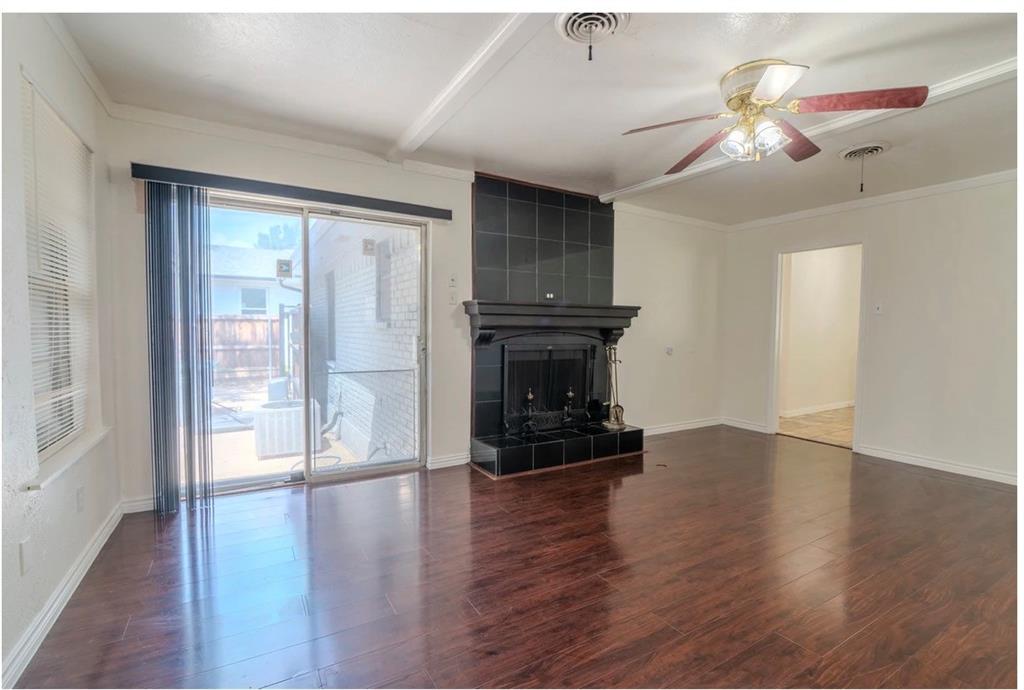 8017 Woodhue Road Dallas, TX 75228 - Photo 8 of 20 Rich wood-finish flooring with a fireplace featuring a tiled surround and mantel