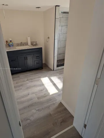 a view of a livingroom with wooden floor and a sink