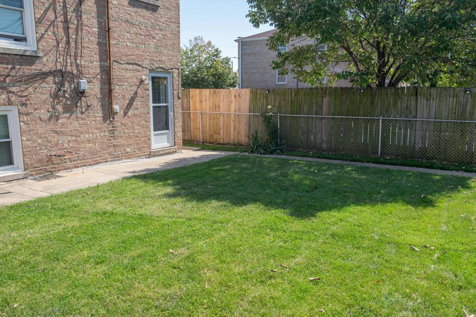 5520 South Pulaski Road, Unit 2 Chicago, IL 60629 - Photo 42 of 44 a view of a backyard with a fence and trees