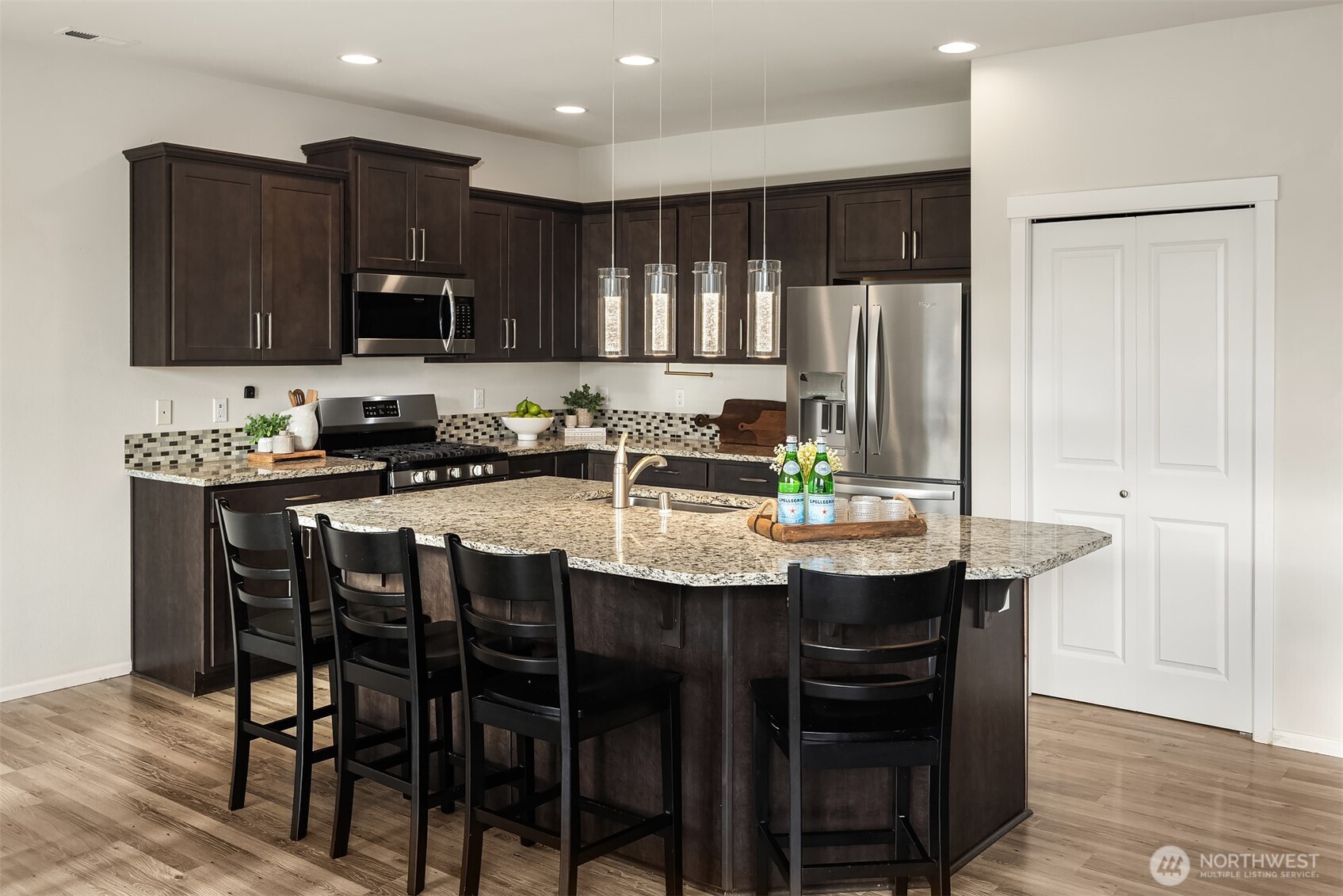 17604 Quartz Street Granite Falls, WA 98252 - Photo 5 of 40 a kitchen with stainless steel appliances kitchen island granite countertop a table chairs microwave and sink
