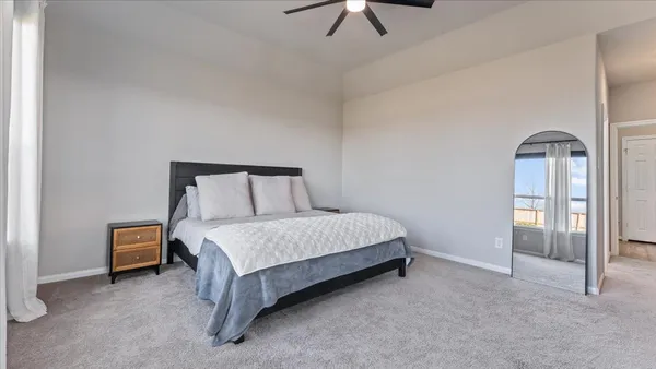 a spacious bedroom with a bed and a window