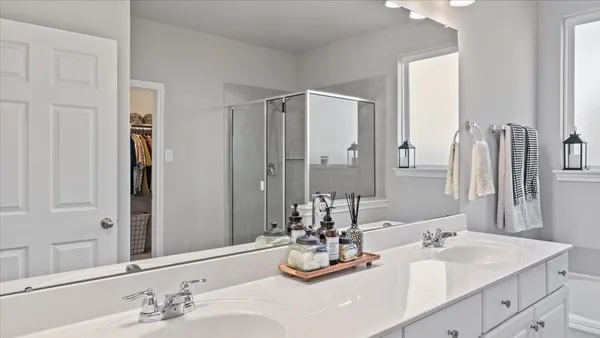 a bathroom with double vanity and a mirror