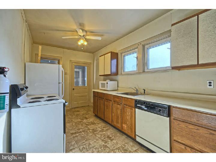 407 North Broadway Pitman, NJ 08071 - Photo 7 of 20 a kitchen with kitchen island granite countertop cabinets a sink a stove and a refrigerator