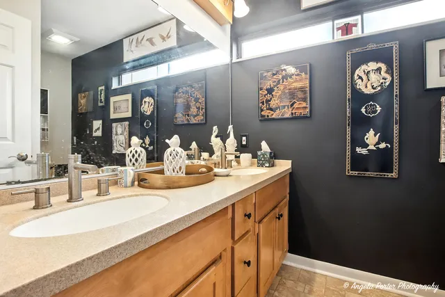 a bathroom with double vanity sinks and a mirror