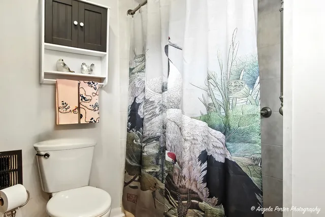 a bathroom with a toilet sink and shower curtain