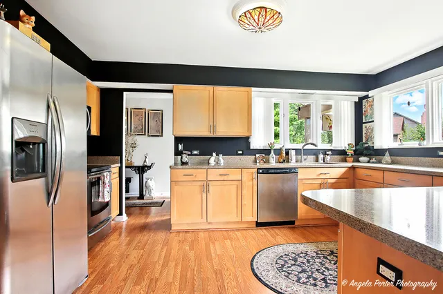 a kitchen with stainless steel appliances granite countertop a stove a sink and a refrigerator