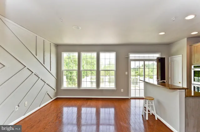 a kitchen with stainless steel appliances granite countertop a refrigerator a stove top oven and a refrigerator with wooden floors