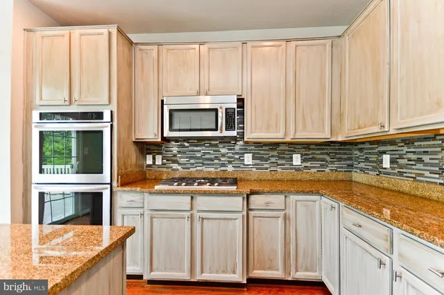 a kitchen with granite countertop a sink and a wooden floor