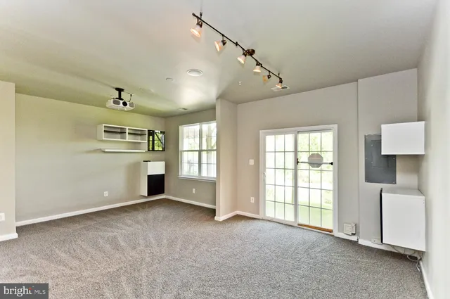 an empty room with windows and fireplace