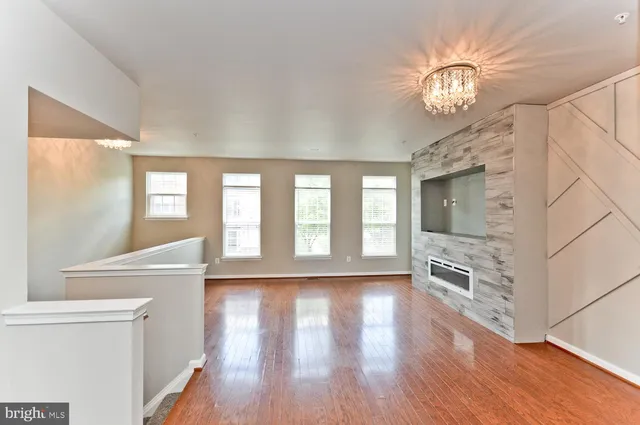 an empty room with windows and fireplace