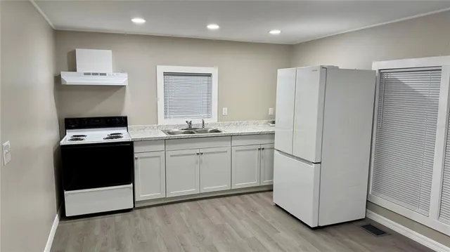 a kitchen with a refrigerator and a stove top oven