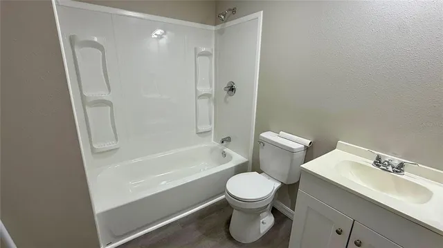 a white toilet sitting next to a bath tub