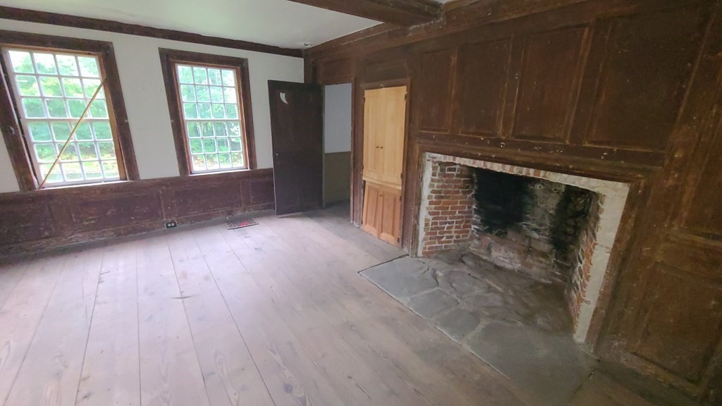 1442 Main Road Granville, MA 01034 - Photo 14 of 27 an empty room with wooden floor fireplace and windows