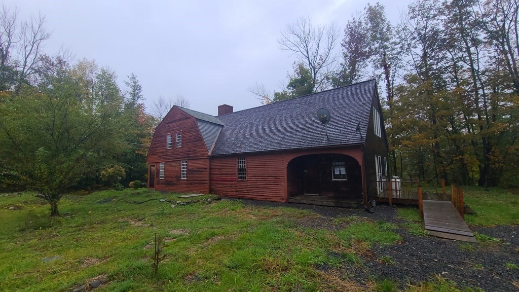 1442 Main Road Granville, MA 01034 - Photo 4 of 27 a view of a wooden house with a small yard and large tree