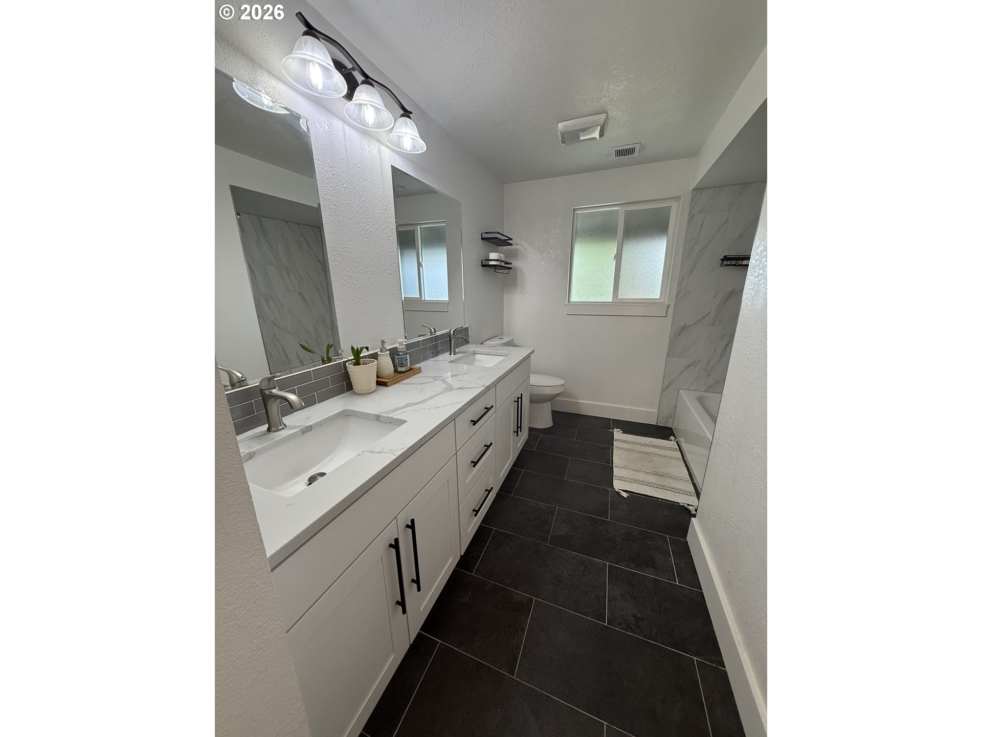 6974 Glacier Drive Springfield, OR 97478 - Photo 23 of 37 a bathroom with a double vanity sink and mirror