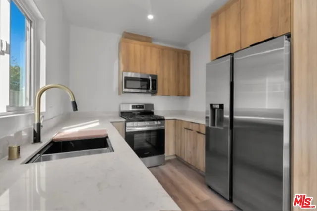 a kitchen with stainless steel appliances a refrigerator sink and a stove