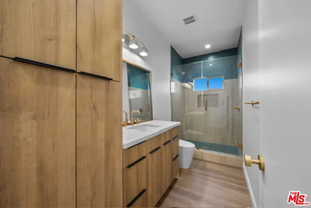 a bathroom with a double vanity sink toilet and shower