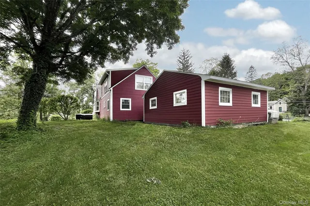 a view of a yard in front of a house with a large tree