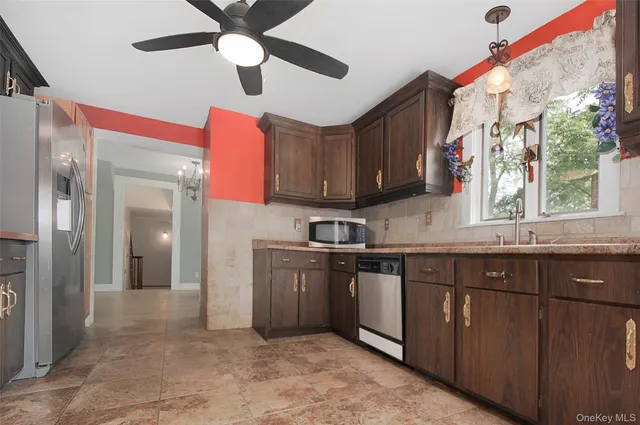 a kitchen with stainless steel appliances granite countertop a sink and dishwasher a stove top oven with wooden floor