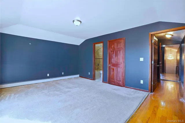 a view of an empty room with a window and bathroom