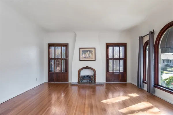 a view of a livingroom with wooden floor and a large window